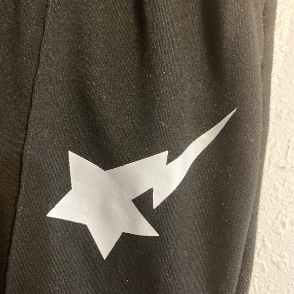 Black pants with shooting star logo on front and bottom flare legs - Picture 2 of 3